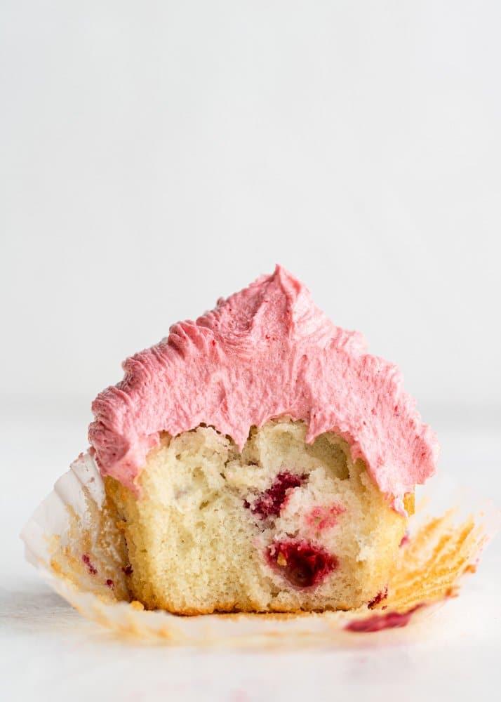a raspberry cupcake with a bite taken out of it