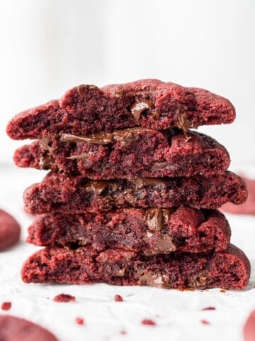 vegan red velvet cookies broken in half and stacked on top of each other