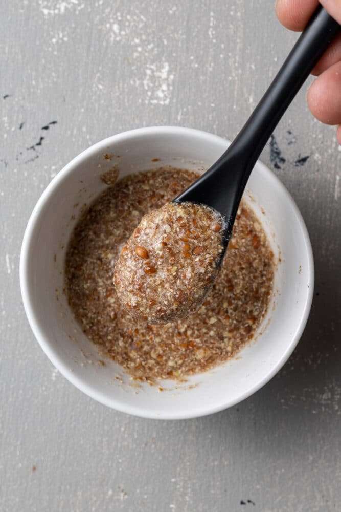 a flax egg in a bowl with a spoon scooping some out
