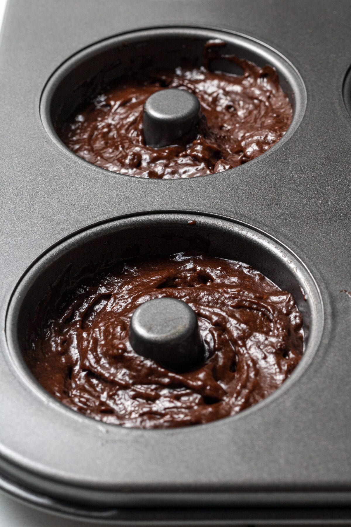 chocolate donut batter in a pan before being baked