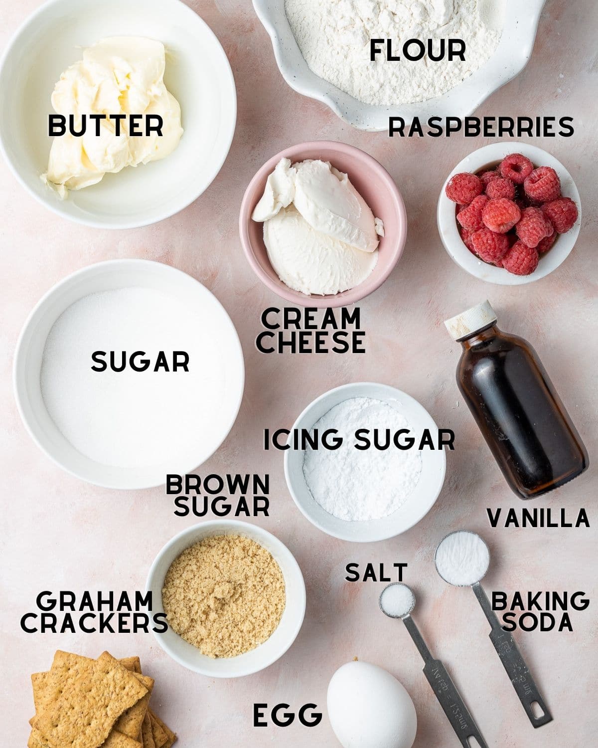ingredients to make raspberry cheesecake cookies in bowls with labels