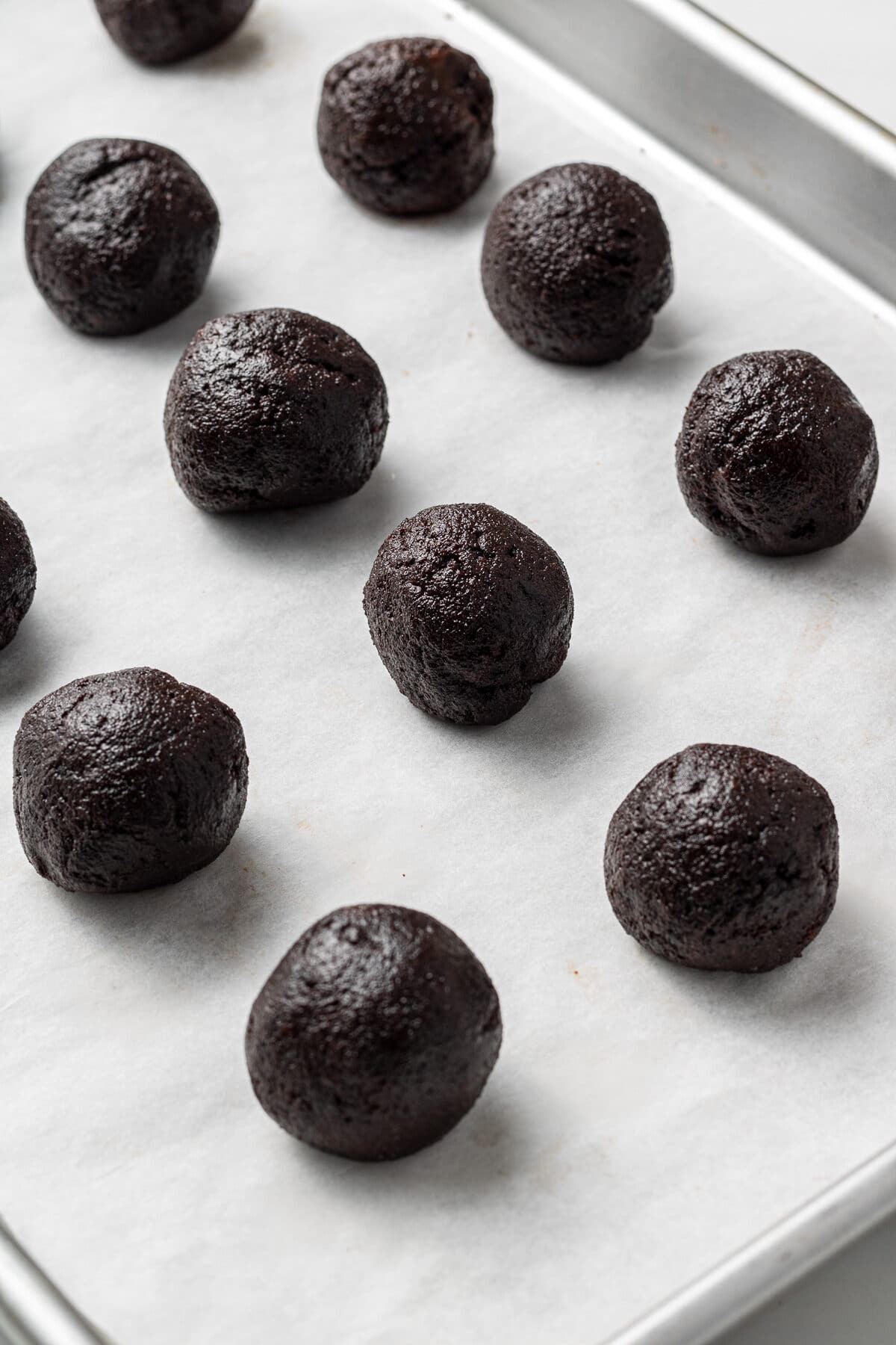 chocolate cake balls on a parchment lined baking sheet