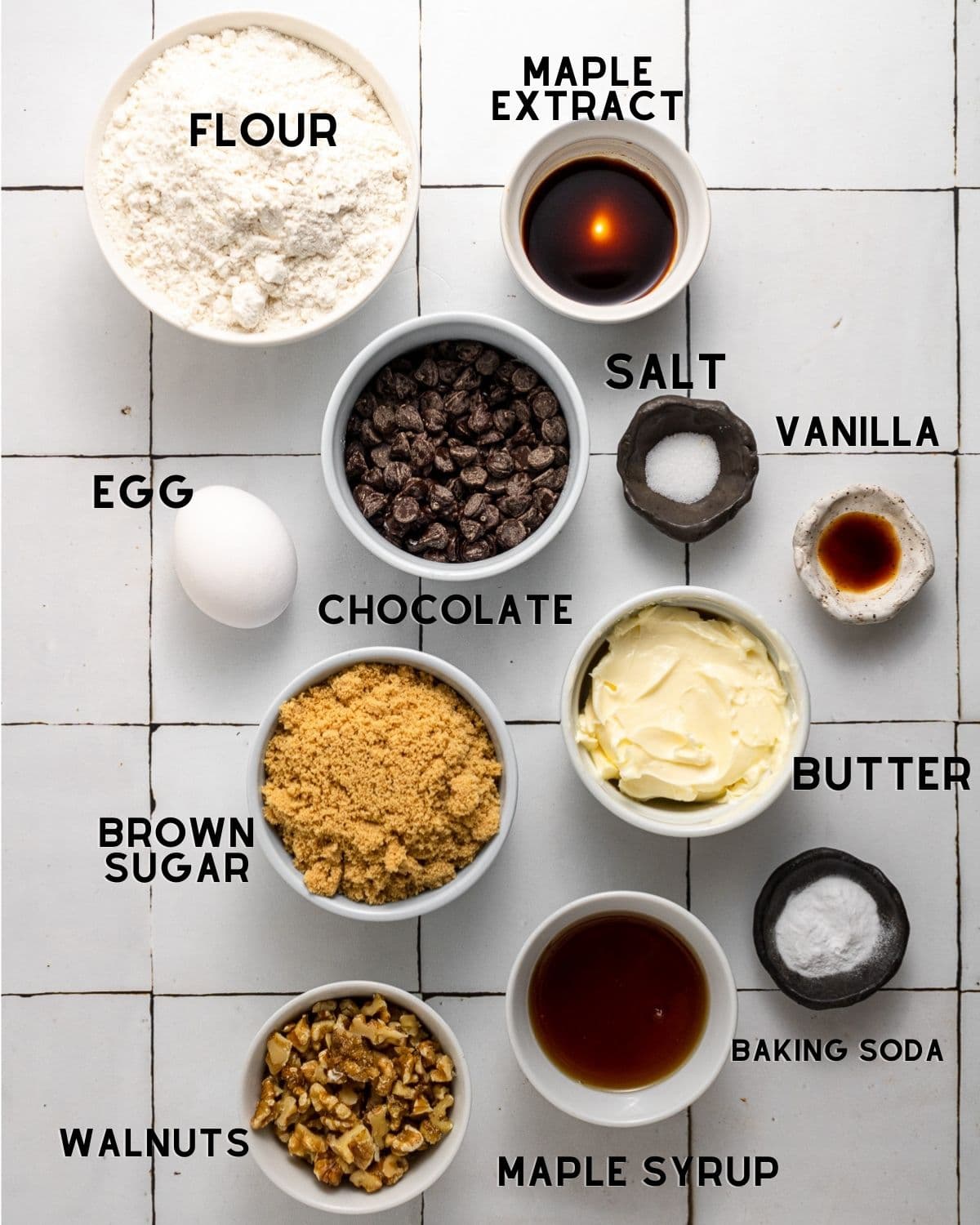 ingredients needed to make maple chocolate chip cookies in bowls with labels