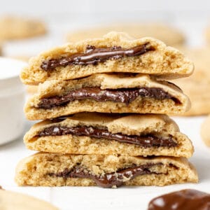 chocolate nutella filled cookies split in half and stacked with a spoon of nutella beside them