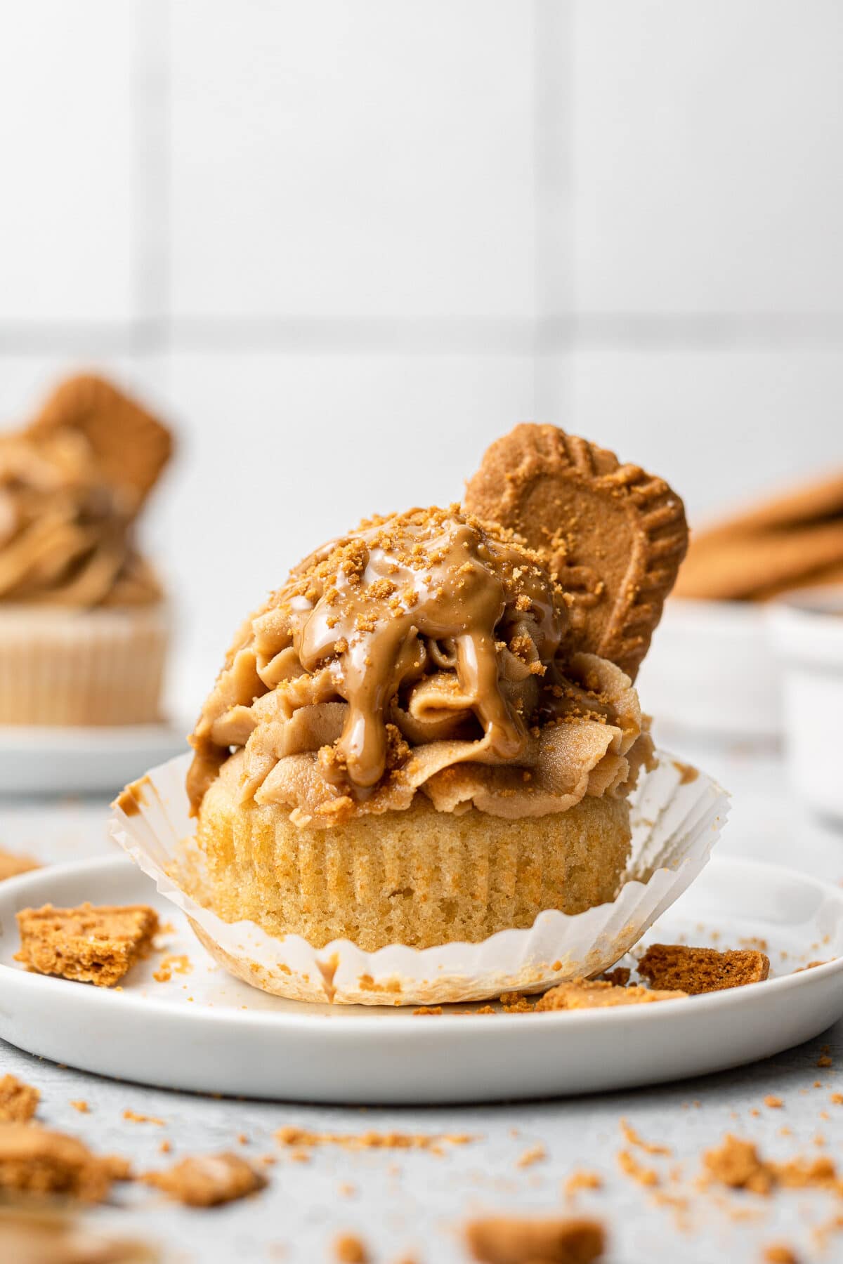biscoff cupcake on a plate with crushed biscoff cookies scattered around