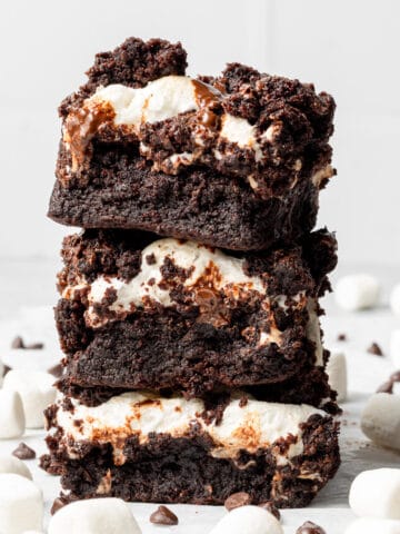 marshmallow brownies stacked on top of each other with chocolate chips scattered around