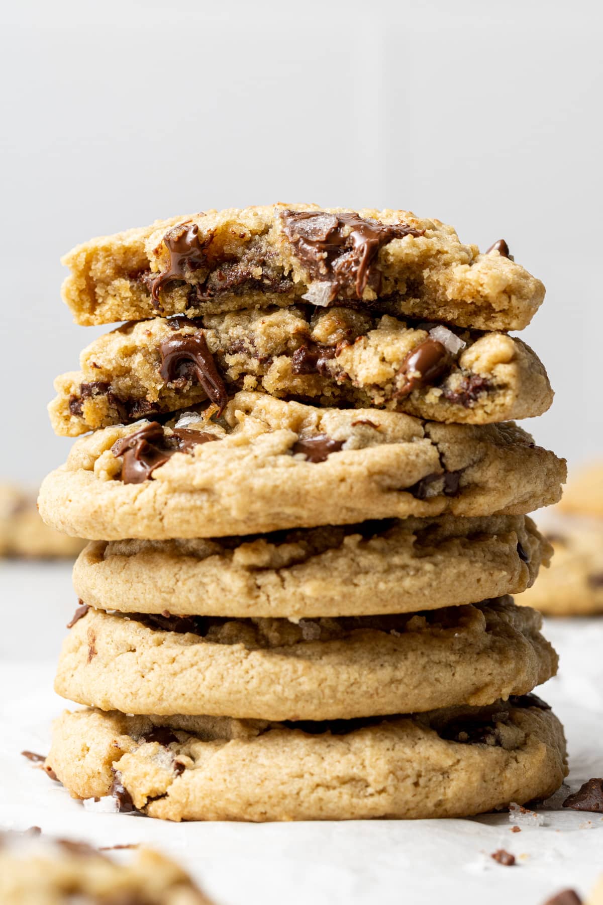 oat flour chocolate chip cookies stacked on top of each other with the top one split in half