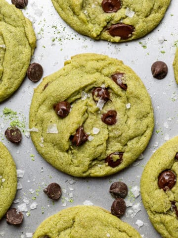 Baking sheet of matcha cookies with chocolate chips and sprinkled with sea salt