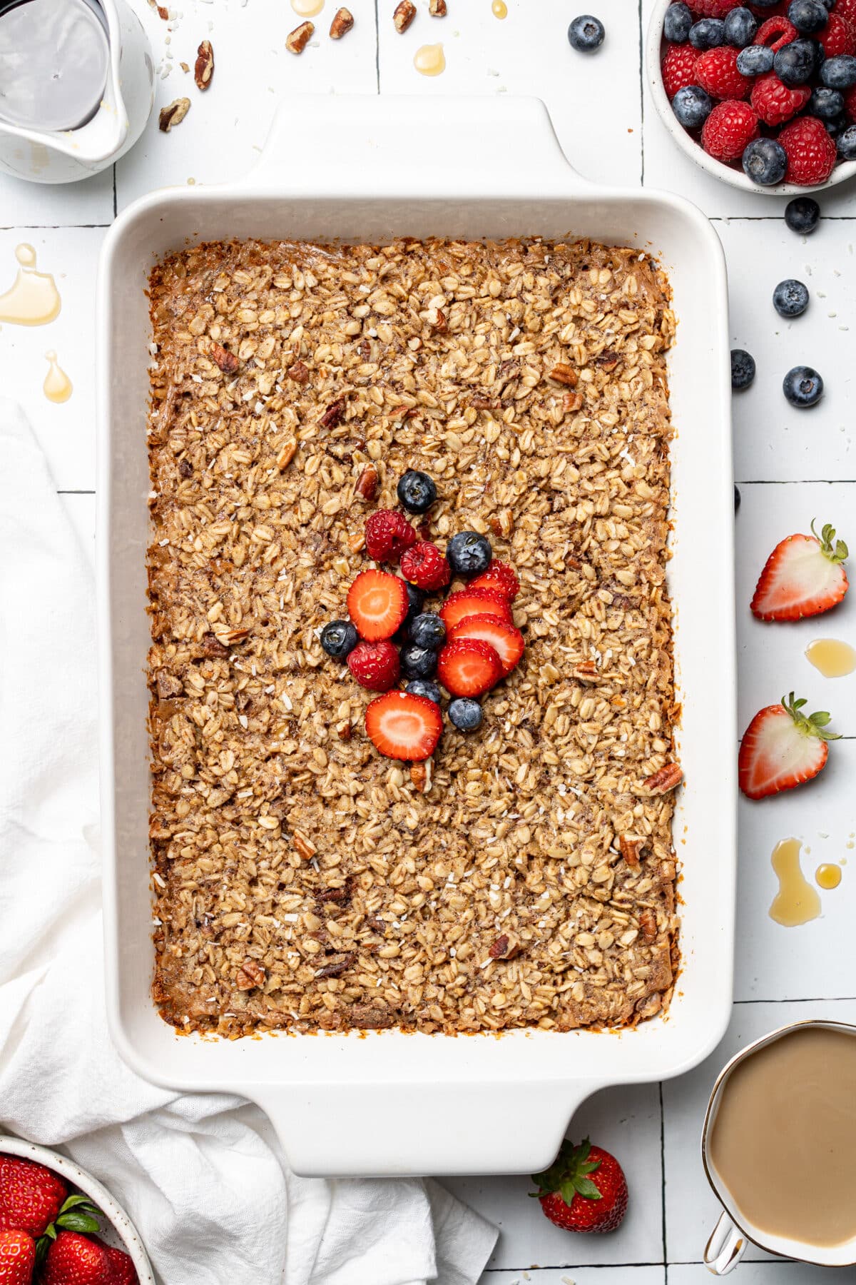 Casserole dish of baked oats topped with berries and pictured from above