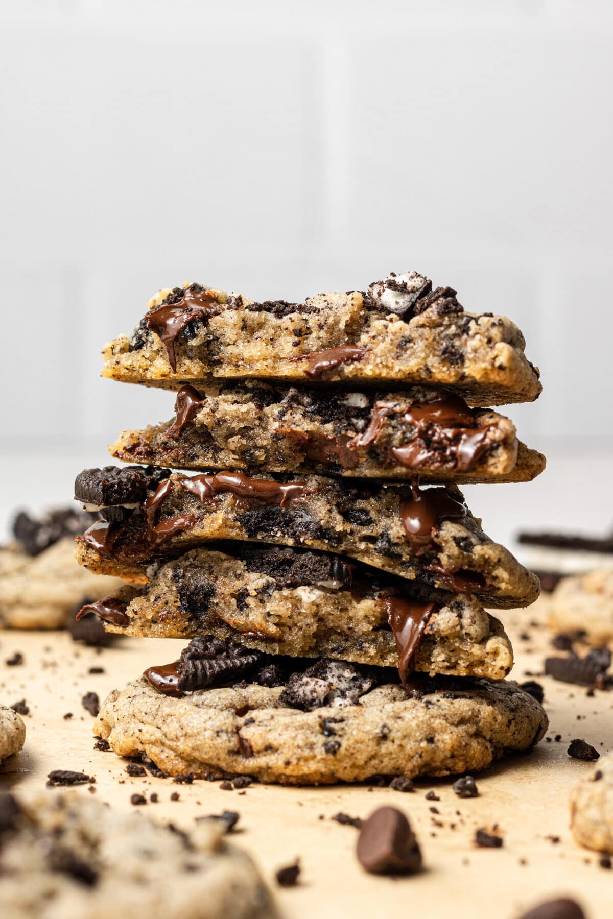 Oreo chocolate chip cookies stacked and broken in half with chocolate chips scattered around