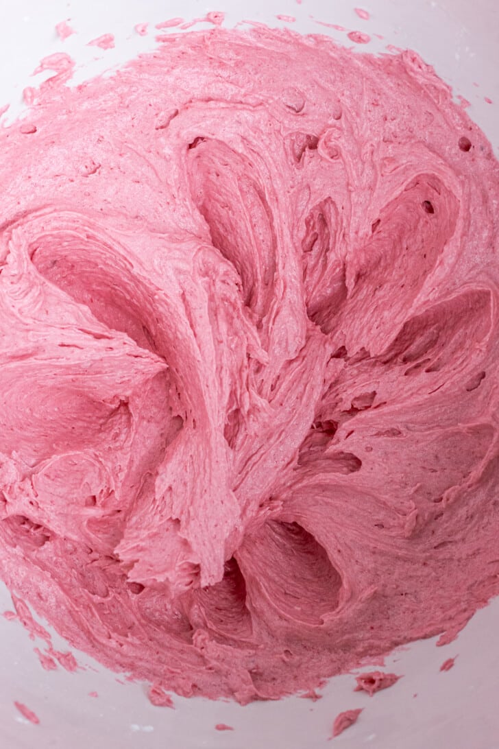raspberry buttercream closeup in a white bowl.