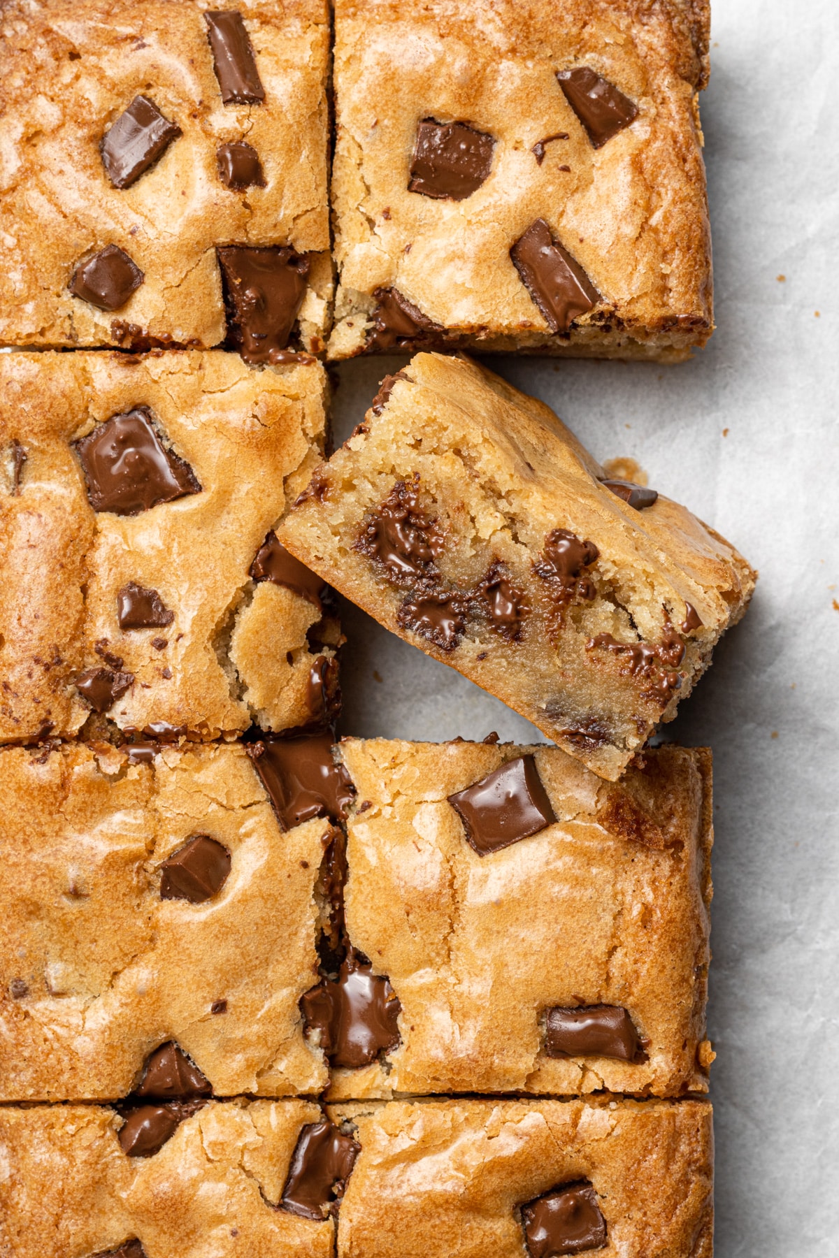Sheet of blondies with big chocolate chunks and one blondie turned on its side