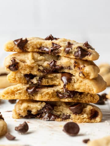dairy free chocolate chip cookies split in half and stacked on top of each other with chocolate chips scattered around