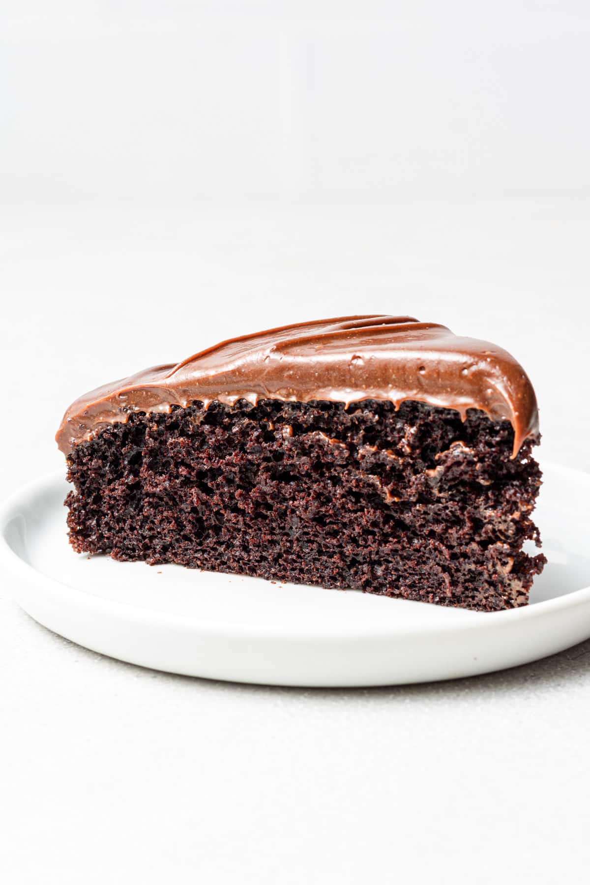 Chocolate fudge cake slice on a white plate