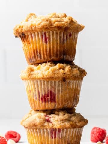 Three raspberry white chocolate muffins stacked on top of each other