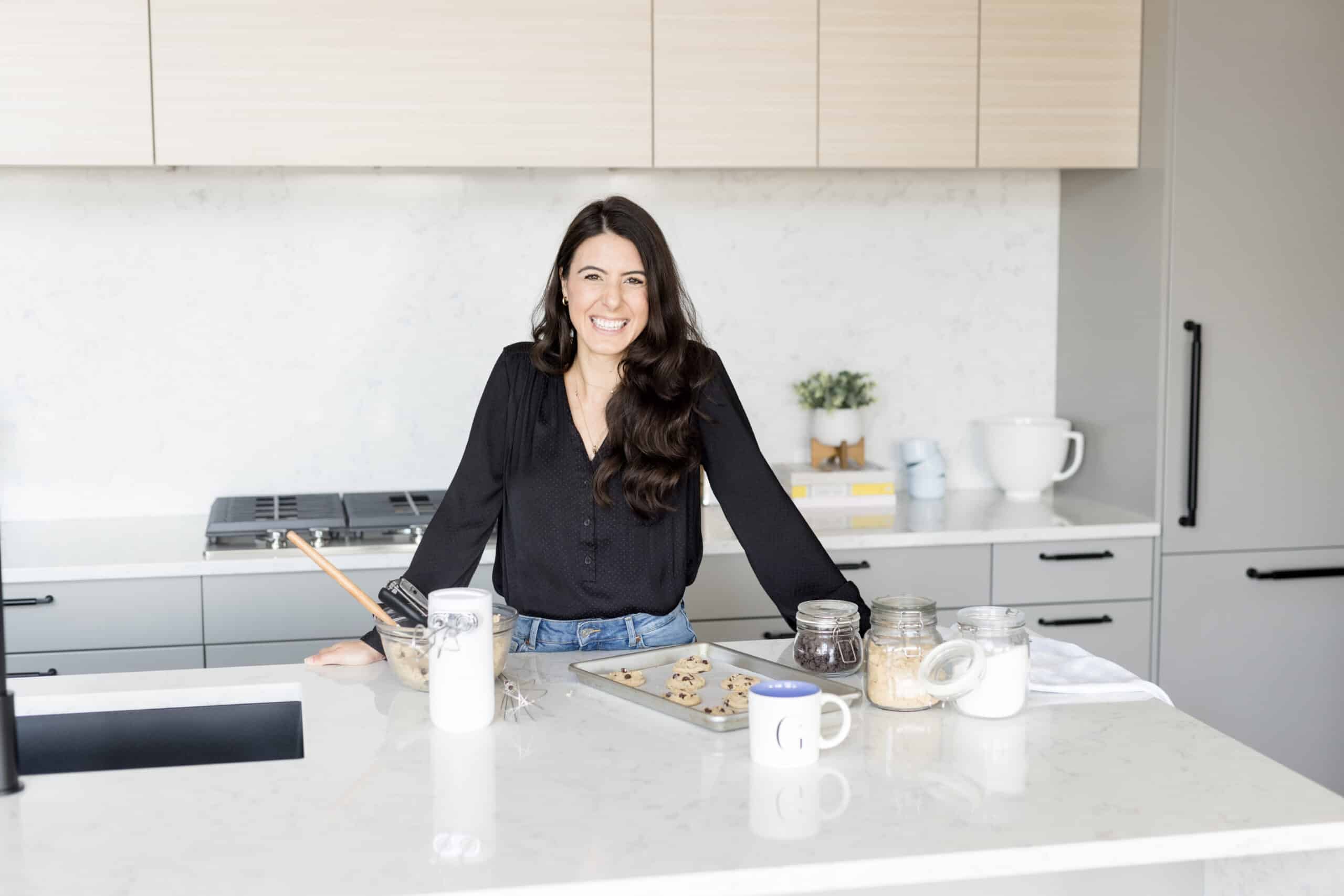 photo of a woman at a kitchen counter smiling