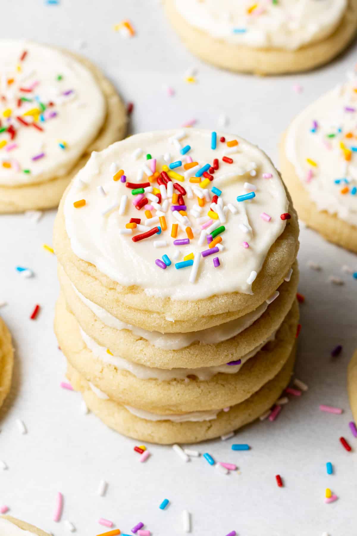 four Buttercream Frosted Sugar Cookies stacked on top of each other