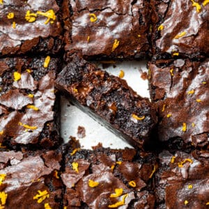 chocolate orange brownies cut into squares with one in the middle on it's side
