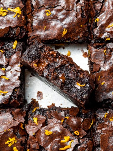 chocolate orange brownies cut into squares with one in the middle on it's side