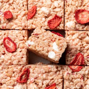 strawberry rice krispies cut into squares with on in the middle flipped on its side