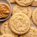 peanut butter cookies without brown sugar on parchment paper with a bowl of peanut butter