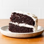 chocolate cake with vanilla frosting slice on a plate