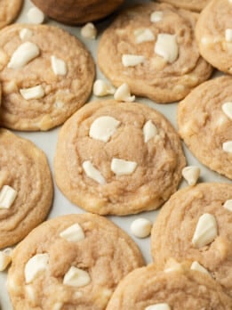 cookies arranged on a blue backdrop with white chocolate chips scattered around them.